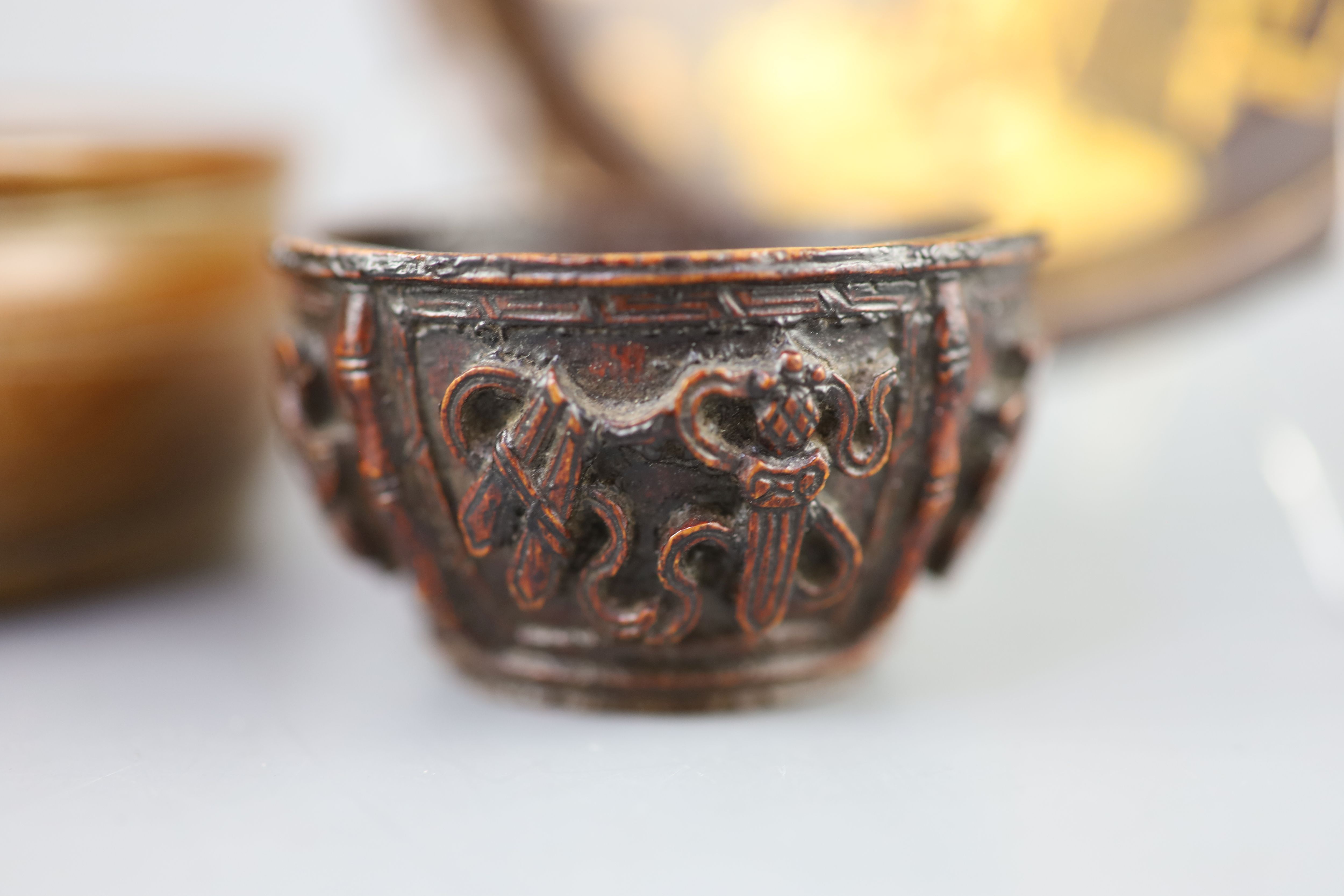 A Chinese carved bamboo cup, a plain bamboo brushwasher, 18th/19th century and a gilt decorated lacquer saucer dish, 17th century,